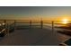 Serene view from a wooden deck, overlooking the calm lake during a golden sunset at 3130 Indian Trl, Eustis, FL 32726