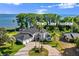 Expansive lakefront home featuring lush landscaping, circular driveway, and an attached three car garage at 3130 Indian Trl, Eustis, FL 32726