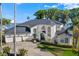 Front exterior featuring three-car garage, circular driveway and well manicured lawn at 3130 Indian Trl, Eustis, FL 32726