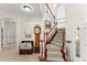Grand foyer with staircase, grandfather clock, and a decorative bench seating area at 3130 Indian Trl, Eustis, FL 32726