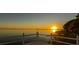 Golden sunrise shining over the serene lake, as seen from the end of the private wooden dock at 3130 Indian Trl, Eustis, FL 32726