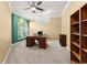 Home office with a large desk, comfortable chair, built-in shelving, and natural light from a large window at 3130 Indian Trl, Eustis, FL 32726