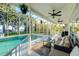 Covered patio area featuring ceiling fans and comfortable seating by the screened in pool at 3130 Indian Trl, Eustis, FL 32726