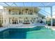 The enclosed pool area features a large pool, multiple seating areas, and a spiral staircase to the second floor at 3130 Indian Trl, Eustis, FL 32726