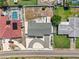 An aerial view shows a one-story house with a driveway and a neighboring pool at 324 Plaza Blvd, Daytona Beach, FL 32118
