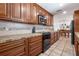 Well-lit kitchen features wood cabinets, tile backsplash, oven, and tile floors at 324 Plaza Blvd, Daytona Beach, FL 32118