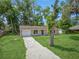 Exterior of home with a spacious lawn, a driveway, and an attached garage at 330 Ponce Deleon Blvd, De Leon Springs, FL 32130
