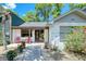 Inviting front porch with stone walkway, red chairs, and potted plants leading to a glass-paneled front door at 330 Wall Ave, Ormond Beach, FL 32174