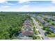 Aerial view of the community featuring a tranquil pond and lush green forest at 43 Pergola Pl, Ormond Beach, FL 32174
