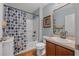 Bright bathroom featuring a vanity, toilet, and a bathtub with a stylish blue and brown patterned shower curtain at 43 Pergola Pl, Ormond Beach, FL 32174
