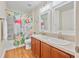 Bright bathroom features dual sinks, wood floors, and shower with flamingo shower curtain at 43 Pergola Pl, Ormond Beach, FL 32174