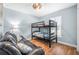 Comfortable bedroom featuring a sturdy black bunk bed, a leather futon, and a bright window with shutter-style blinds at 43 Pergola Pl, Ormond Beach, FL 32174