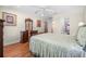 Bright bedroom with wood floors, dresser, ceiling fan, and view to the ensuite bathroom at 43 Pergola Pl, Ormond Beach, FL 32174