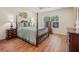 Inviting bedroom with a four-poster bed, warm lighting, and wood flooring at 43 Pergola Pl, Ormond Beach, FL 32174