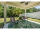 Relaxing covered patio with seating area offers views of the lush backyard at 43 Pergola Pl, Ormond Beach, FL 32174