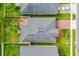 Aerial view of a home featuring a gray roof, green lawn, and a brick-paved driveway and back patio at 5635 Estero Loop, Port Orange, FL 32128
