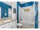 Charming bathroom with a shower and tub, white subway tile, blue walls, and a vanity with a granite countertop at 5635 Estero Loop, Port Orange, FL 32128