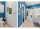 Well-lit blue and white bathroom with a tiled floor, a glass-enclosed shower, and a modern white vanity at 5635 Estero Loop, Port Orange, FL 32128