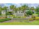 Westport community entrance featuring a stone sign surrounded by palm trees and well-maintained landscaping at 5635 Estero Loop, Port Orange, FL 32128