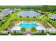 Aerial view of the Westport community pool, featuring lounge chairs, palm trees, a lake, and well-kept landscaping at 5635 Estero Loop, Port Orange, FL 32128