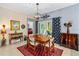 Cozy dining area with a wooden table, eclectic decor, and view to the screened patio at 5635 Estero Loop, Port Orange, FL 32128
