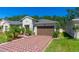 A well-manicured front yard and a brick driveway lead to this charming single-Gathering home with a two-car garage at 5635 Estero Loop, Port Orange, FL 32128