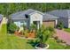 Beautifully landscaped home featuring vibrant green lawns, mature trees, and a circular driveway at 5635 Estero Loop, Port Orange, FL 32128