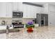 Bright kitchen featuring stainless steel appliances, granite countertops, and white cabinetry at 5635 Estero Loop, Port Orange, FL 32128