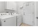 Clean laundry room with a washer, a dryer, storage cabinets, and a door to the exterior at 5635 Estero Loop, Port Orange, FL 32128