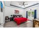 Tranquil bedroom featuring a tray ceiling, large bed, and a view of the outside greenery at 5635 Estero Loop, Port Orange, FL 32128