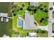 Aerial view of a waterfront home featuring a private pool, boat dock, lush landscaping and fully fenced in yard at 5809 Riverside Dr, Port Orange, FL 32127