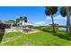A spacious backyard with a lawn, pool, outdoor seating, and water views at 5809 Riverside Dr, Port Orange, FL 32127
