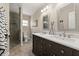 Bathroom featuring double sinks with marble countertops, dark cabinetry, and a glass shower enclosure at 5809 Riverside Dr, Port Orange, FL 32127
