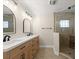 Well-lit bathroom with double sink vanity, quartz countertop, and glass-enclosed shower at 5809 Riverside Dr, Port Orange, FL 32127