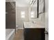 A bathroom featuring a dark vanity with marble countertop, with a combination shower and tub at 5809 Riverside Dr, Port Orange, FL 32127