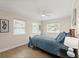 Cozy bedroom featuring a ceiling fan, two windows, and light-colored walls and trim at 5809 Riverside Dr, Port Orange, FL 32127