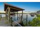 Covered boat lift for easy access to the water with tropical landscaping and serene surroundings at 5809 Riverside Dr, Port Orange, FL 32127