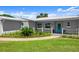 Close up on single-story home with fresh exterior paint, manicured lawn and lush landscaping at 5809 Riverside Dr, Port Orange, FL 32127