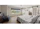 Comfortable main bedroom with water view, barn door to bath, neutral decor, and abundant natural light at 5809 Riverside Dr, Port Orange, FL 32127