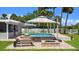 Inviting backyard with a sparkling pool, sun loungers, and a fire pit for outdoor relaxation at 5809 Riverside Dr, Port Orange, FL 32127