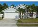 Charming single-story home with a two-car garage, palm trees, and well-maintained landscaping in a residential neighborhood at 8958 Fort Jefferson Blvd, Orlando, FL 32822