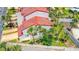 Inviting two-story townhome featuring white exterior, red roof, mature palms, and well-manicured landscaping at 200 Florida Shores Blvd, Daytona Beach, FL 32118
