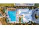 Aerial view of the pool area with lounge chairs, tiki huts, and well manicured landscaping at 324 Coral Reef Way, Daytona Beach, FL 32124