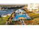 Scenic aerial view of community pool, tiki huts, lounge chairs, and meticulously kept grounds at 324 Coral Reef Way, Daytona Beach, FL 32124