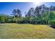 Expansive backyard featuring lush lawn and mature trees offering natural privacy at 324 Coral Reef Way, Daytona Beach, FL 32124