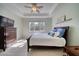 Bright bedroom featuring tray ceiling, a ceiling fan, wood-look flooring, and a window at 324 Coral Reef Way, Daytona Beach, FL 32124