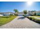 Wide brick driveway leading to a beautiful home with well-manicured lawn and tropical landscaping at 324 Coral Reef Way, Daytona Beach, FL 32124