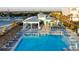 A clear blue pool area with shade structures, lounge chairs, and outdoor dining areas at 324 Coral Reef Way, Daytona Beach, FL 32124