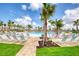 Resort style pool with white lounge chairs, palm trees and beautiful landscaping make for a relaxing day at 324 Coral Reef Way, Daytona Beach, FL 32124
