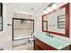 Bathroom features a glass vessel sink with wood cabinetry and a tub with tile surround at 530 Estates Pl, Longwood, FL 32779